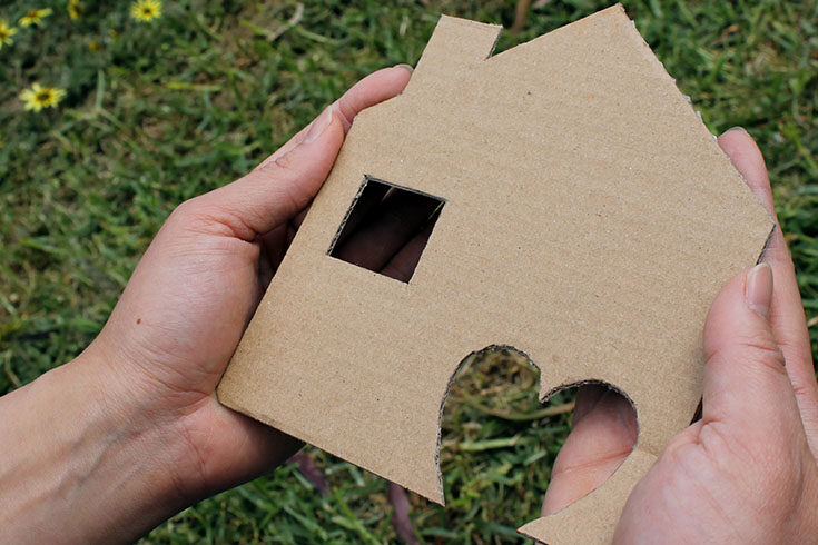 two-hands-holding-a-cardboard-house Two hands holding a cardboard house