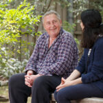 Woman and man chatting while sitting in a park