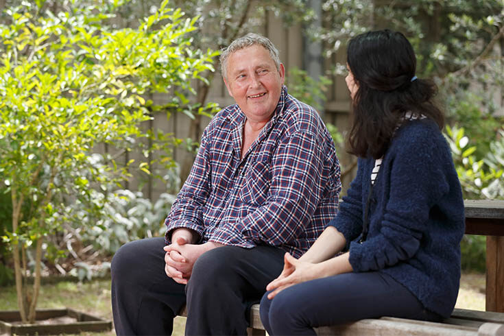woman-talking-to-man-sitting-in-park Woman and man chatting while sitting in a park