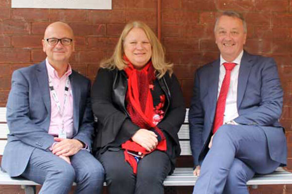 Cathy Humphrey and Martin Foley sitting in front of Sacred Heart Mission's Dining Hall