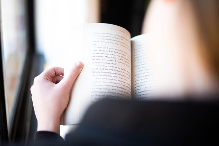 person with their back to the camera reading a book