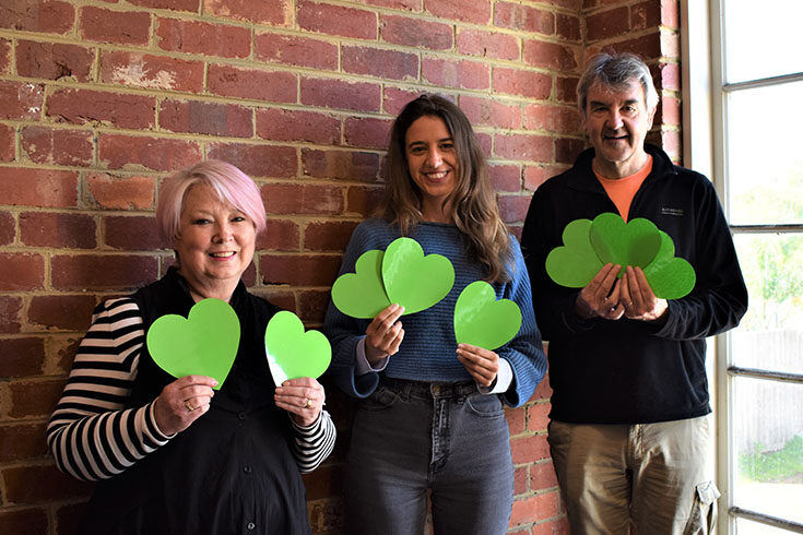 greenlight-heart-team Three GreenLight Heart team members holding green cardboard cards into the camera
