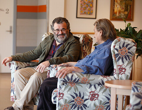 A resident and one of our staff members chatting in the lounge area of our Sacred Heart Community
