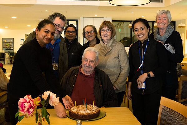 winn-sharing-birthday-cake-with-residents Winn Tuck sharing a birthday cake with Sacred Heart Community residents and staff