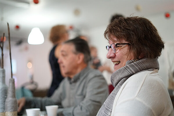 woman-sitting-in-cafe-laughing-talking Woman sitting in a cafe, laughing and talking