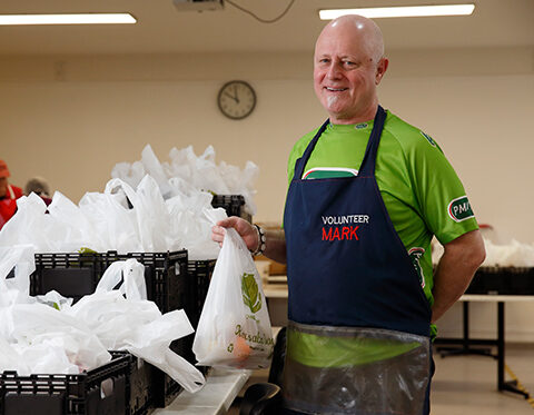 Mark a volunteer holds a meal takeaway bag