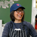 A volunteer in the dining hall smiles and preps food