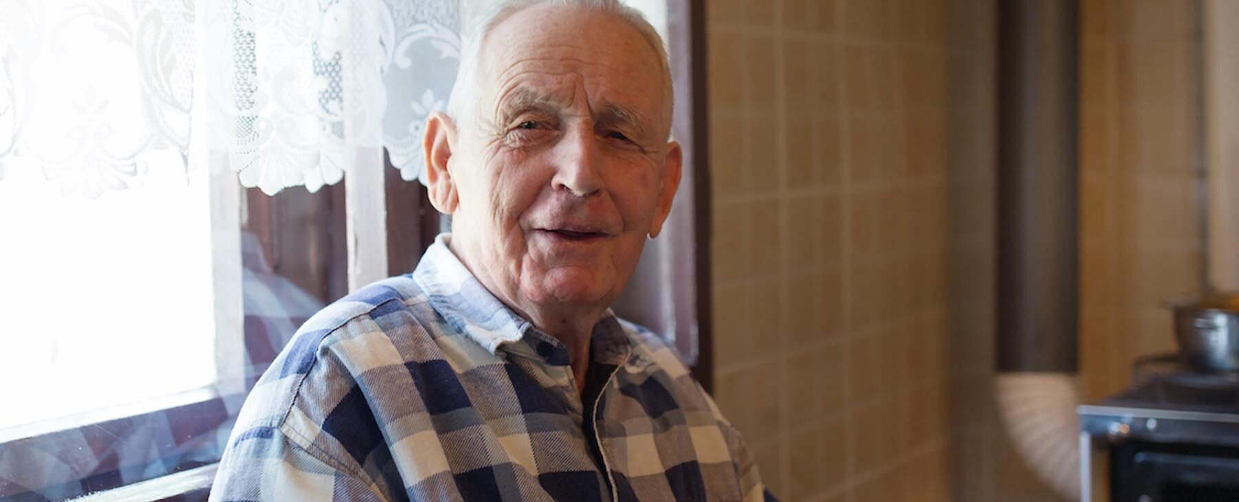 Elderly man sitting in his kitchen