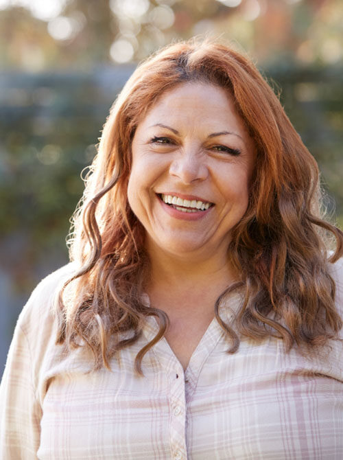 Woman with long auburn hair smiling