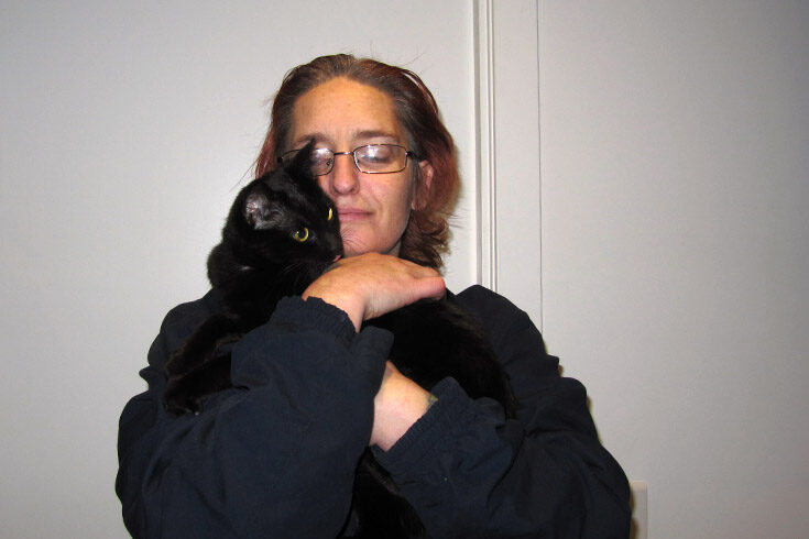 Journey to Social Inclusion participant Mandy hugging her cat
