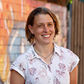 Staff member standing in front of a colourful wall