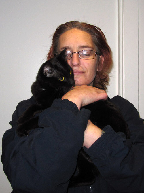 Woman hugging a black cat