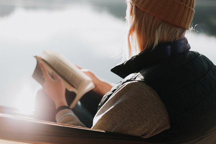 woman-reading-book-outdoors Woman sitting outside and reading a book