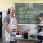 two volunteers working in the dining hall