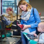 Mother with child paying at the supermarket checkout