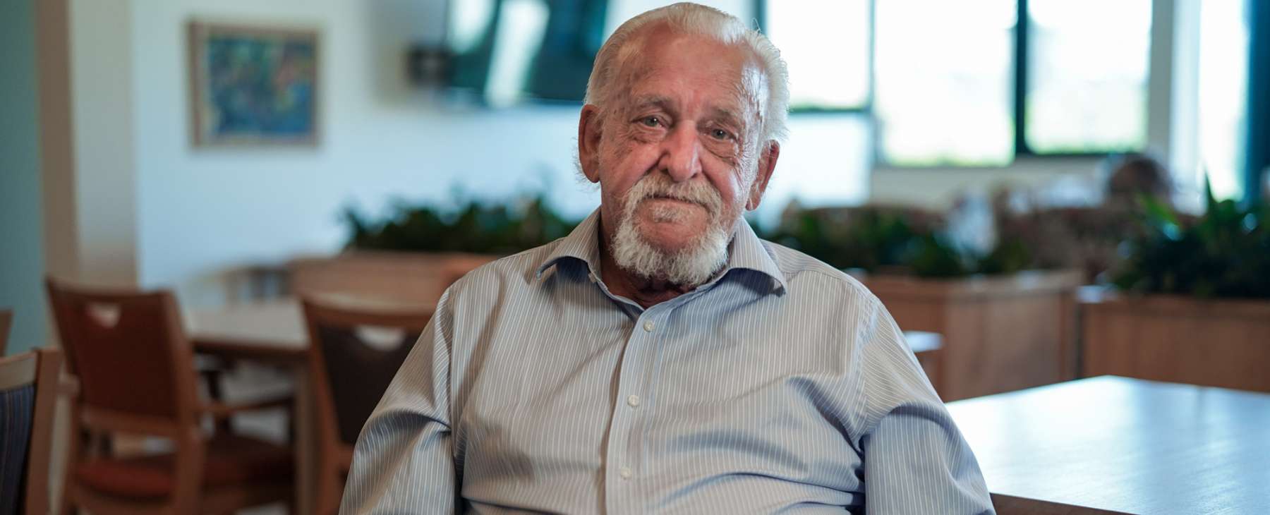 man with a white beard looking into the camera