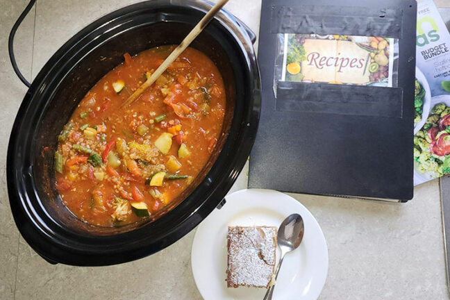 Bethlehem's recipe book next to a pot with home-made stuw and a piece of cake