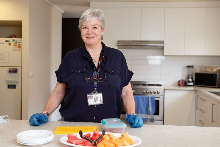 Staff member standing in the Bethlehem kitchen preparing a fruit platter