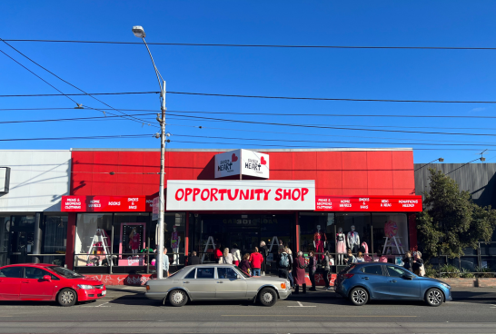 Three cars parked along Sydney Rd Coburg on a Blue sunny day in front of the new Sacred Heart Mission Op Shop.