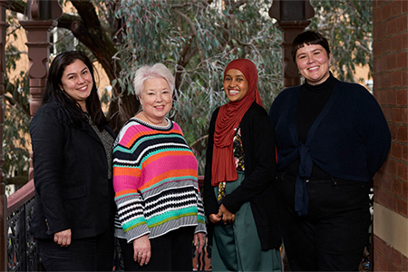 four women smiling in the direction of the camera
