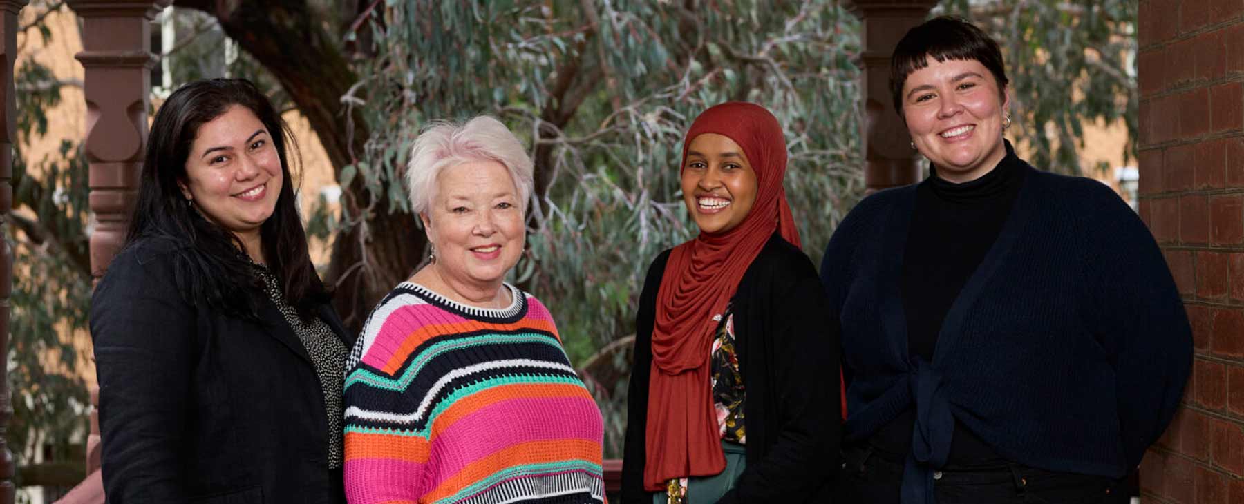 four women smiling in the direction of the camera