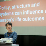 Hang Vo delivering an oration at the launch of the RMIT Social Equity Research Centre. On a slide behind her, the words 