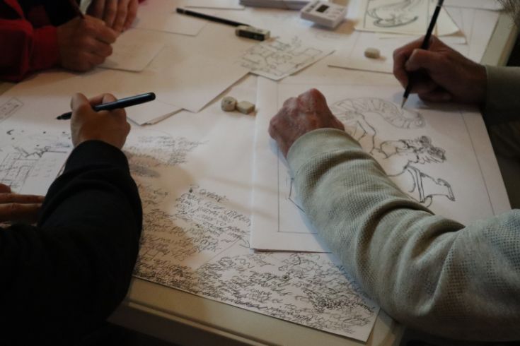 Clients sit together working on their own artworks