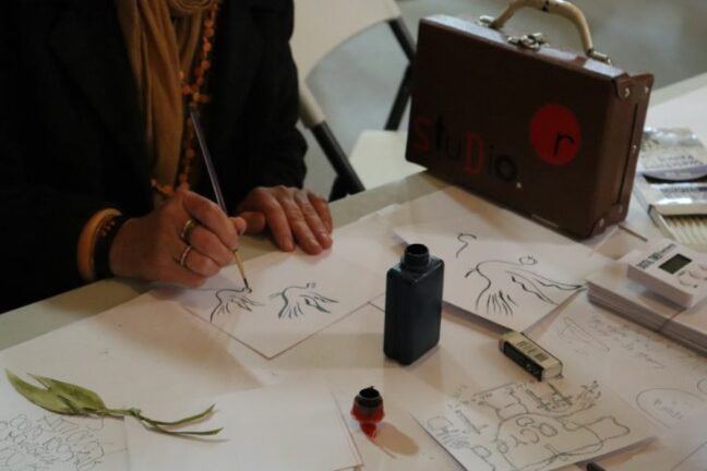 A client works on an ink painting of a dove