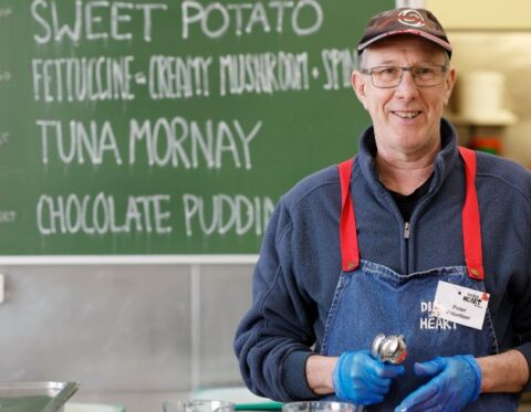 A volunteer preps food in the Dining Hall
