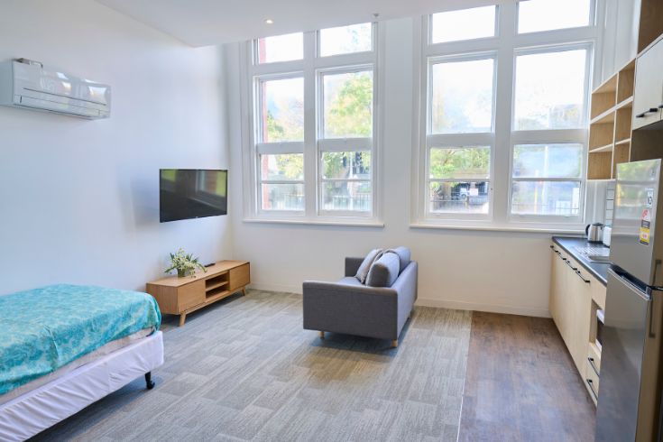 empty apartment with tv, couch and bed